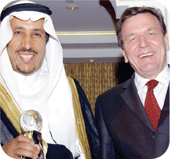 Honouree holding a glass trophy alongside a guest